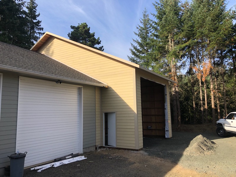 Garage addition with a side door and a large garage door